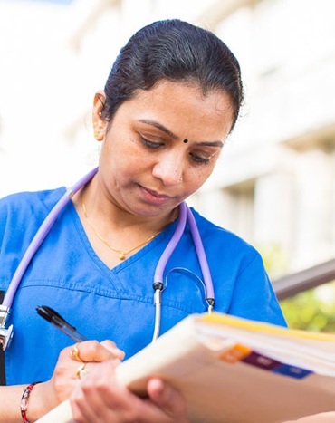 woman in scrubs writing notes